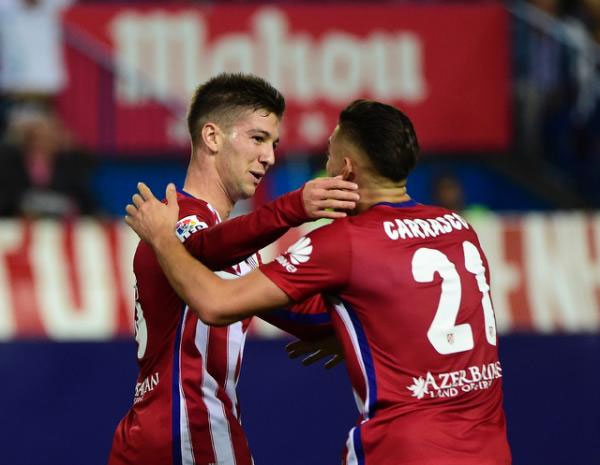 Atletico Madrid's forward Luciano Vietto (L) celebrates with midfielder Yannick Ferreira Carrasco after scoring during a Spanish league football match against Real Madrid at the Vicente Calderon stadium in Madrid on October 4, 2015. PHOTO/AFP