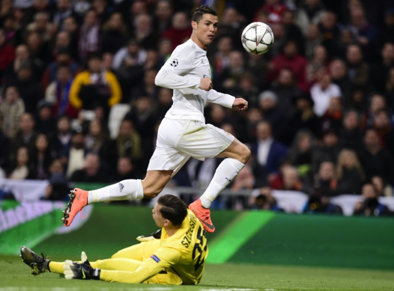 Real Madrid's forward Cristiano Ronaldo (up) attacks Roma's goalkeeper Wojciech Szczesny during the UEFA Champions League at the Santiago Bernabeu stadium in Madrid. PHOTO/AFP.
