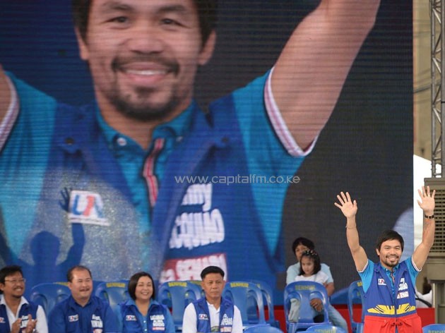 Senatorial candidate of the opposition party and boxing icon Manny Pacquiao greets supporters at a rally in Manila on February 9, 2016 (AFP Photo/Ted Aljibe)