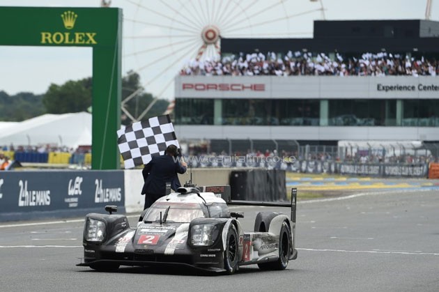 Switzerland's Neel Jani takes the chequered flag as his Porsche 919 Hybrid crosses the finish line to win the 84th Le Mans 24 Hour endurance race in western France, on June 19, 2016.