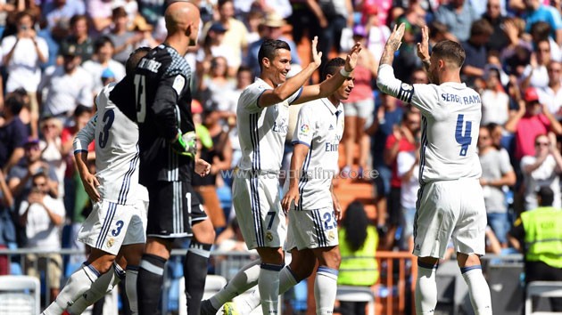 Real Madrid’s Portuguese forward Cristiano Ronaldo (C) celebrates with Real Madrid’s defender Sergio Ramos after scoring during the Spanish league football match Real Madrid CF vs CA Osasuna at the Santiago Bernabeu stadium in Madrid on September 10, 2016.